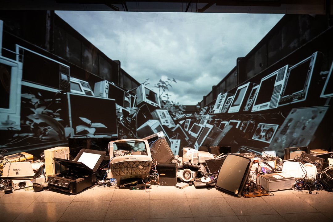 Projeção e equipamentos descartados na instalação. O Mundo Através da IA, Sesc 24 de Maio, São Paulo, 2026.