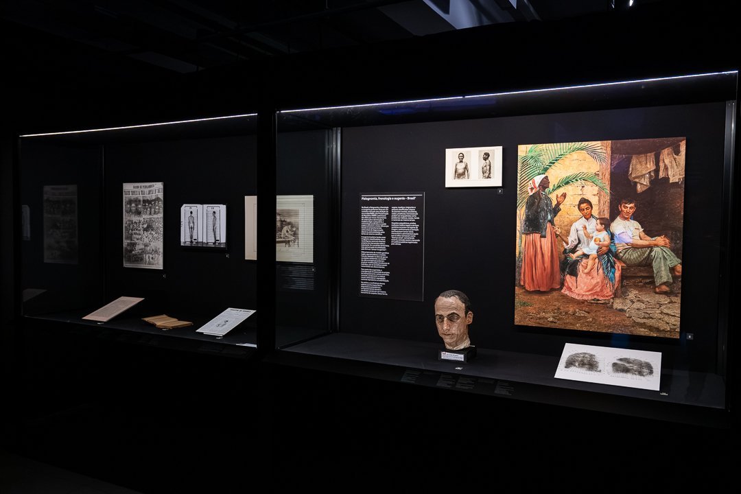 Vitrine com documentos, retratos e reproduções de imagens. O Mundo Através da IA, Sesc 24 de Maio, São Paulo, 2026.